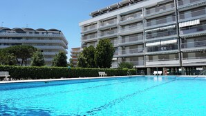 Ein Schwimmbad mit einem modernen Gebäude im Hintergrund.