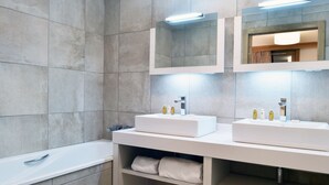 A modern bathroom with two sinks, a bathtub, and built-in shelves. - Charming apartment with parking and pets allowed, near slopes (Courchevel 1550)