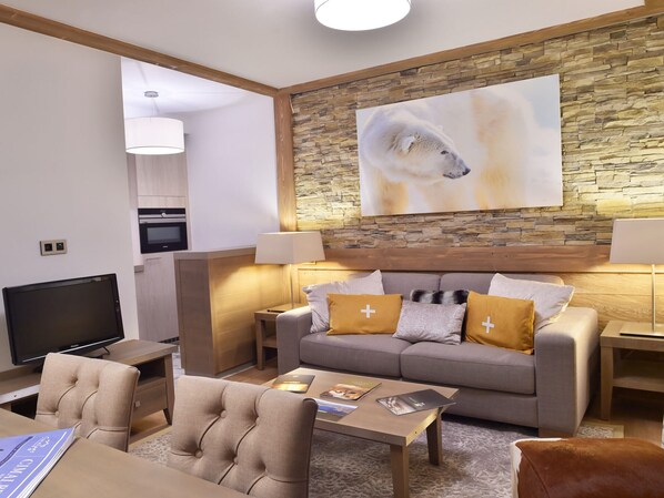 Relax in a cozy space with a comfortable sofa, flat-screen TV, and ample lighting.