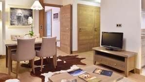 A modern living room with a dining area, a flat-screen TV, and a cowhide rug. - Charming apartment with parking and pets allowed, near slopes (Courchevel 1550)