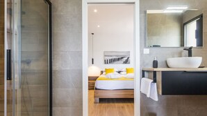 A modern bathroom with a large mirror, a white sink, and a wooden floor. - Gîtes with heated pool near beach. Garden, spa, BBQ, WiFi. Baby bed included (Préfailles)