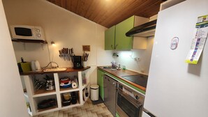 Eine kleine Küche mit Mikrowelle, Toaster, Spüle und Backofen.