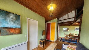 Ein gemütliches Wohnzimmer mit einer Couch, einem Couchtisch und einem Gemälde an der Wand.