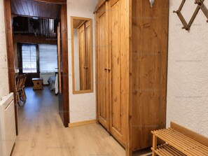 A wooden interior with a wardrobe, a bench, and a dining area with chairs and a table. - Pleasant mountain-style apartment for 6 near shops and cable cars (Le Grand-Bornand)