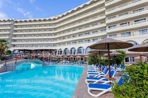 Una piscina al aire libre de temporada, sombrillas