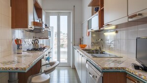 A modern kitchen with a central island, a built-in oven, and a large window. - Roomy and Bright Apartment With Terrace (Roma)