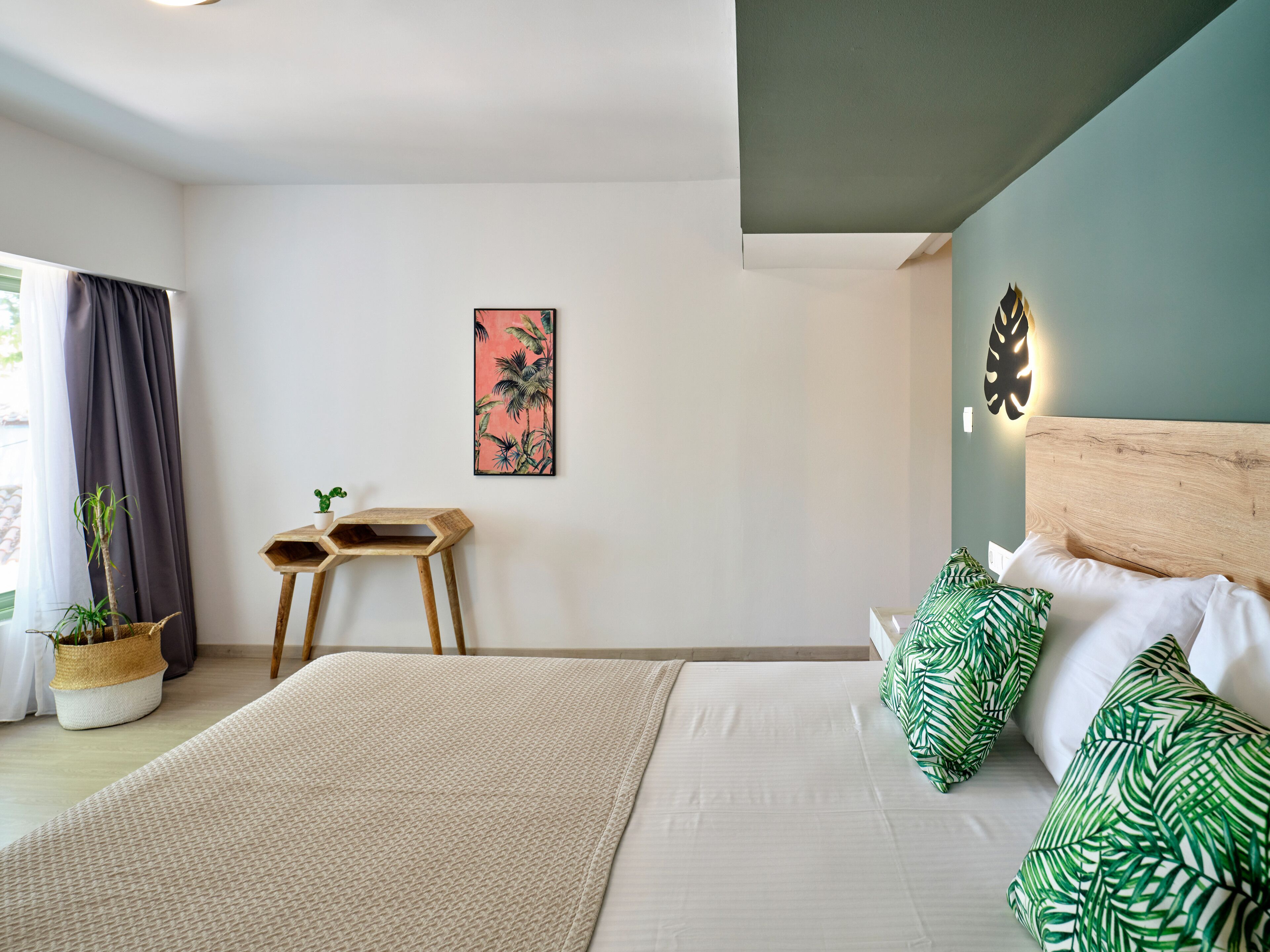 A modern bedroom with a bed, a wall-mounted clock, a small wooden stool, and a potted plant.