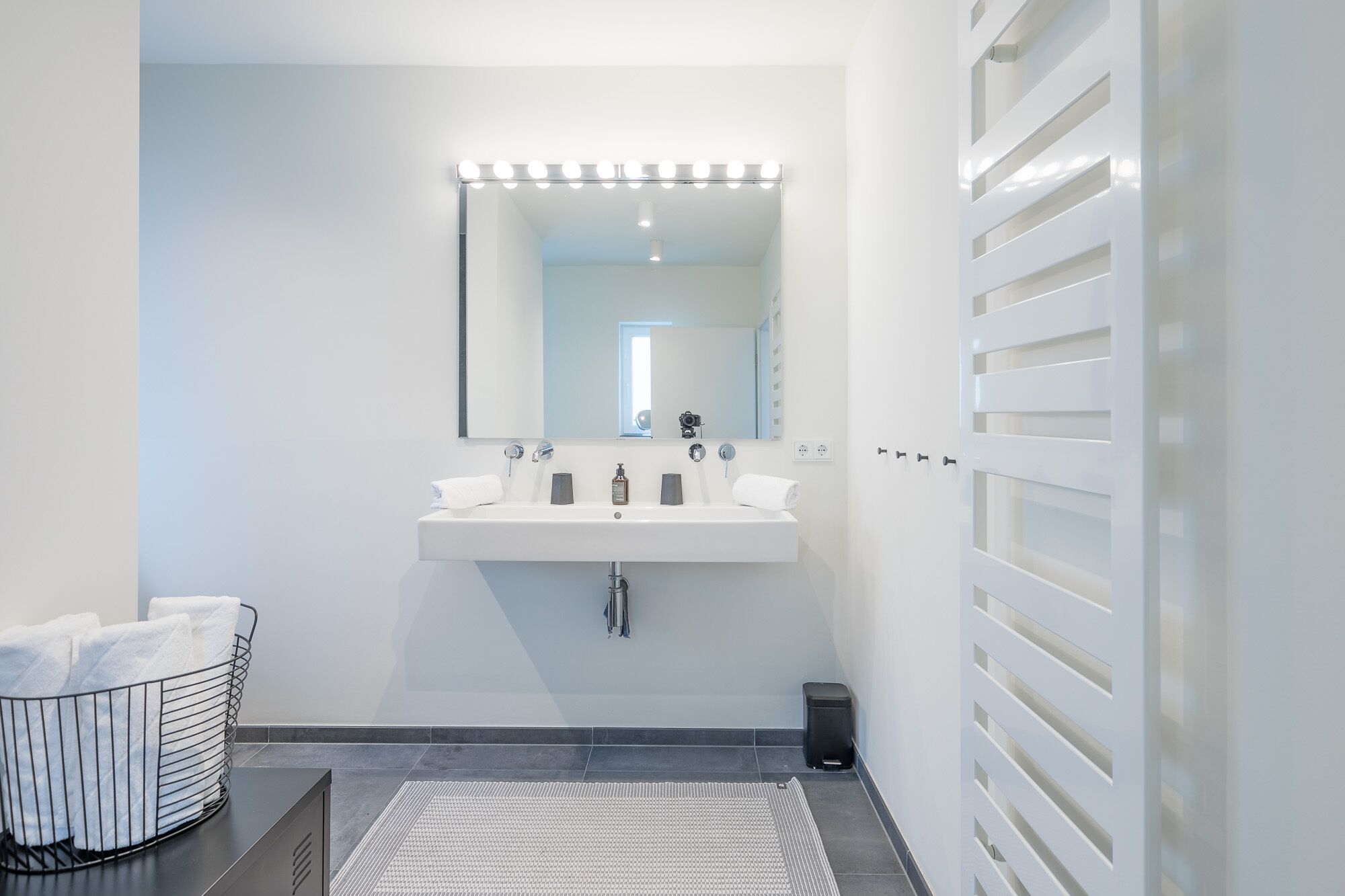 Ein modernes Badezimmer mit Waschbecken, Spiegel und Handtuchhalter.