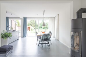 Una cocina moderna con comedor, ventanas amplias y chimenea.