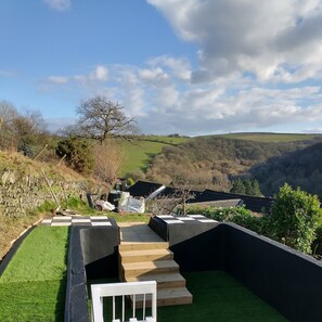 A rooftop terrace with a view of rolling hills, a tree, and a stone wall. - Charming 3-bed Cottage Exmoor Near Barnstaple (Barnstaple)