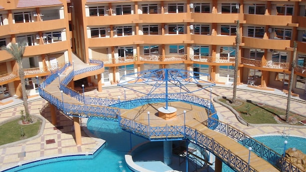 Hotel com vários andares e área de piscina central, com um toboágua espiral e passarelas ao redor.