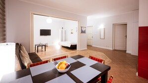 A modern living room with a dining area, a sofa, a TV, and a bed in the background. - Apartment in HEART of Wroclaw-Townhall (Wroclaw)