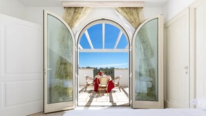 Ein Zimmer mit einer großen Glasdoor, die auf eine Außenpatio mit Tisch und Stühlen führt.