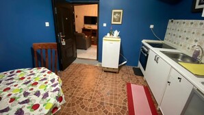 A compact room with a bed, a kitchenette, and a door leading to a living area. - Stunning 2-bed House in Madina (Accra)
