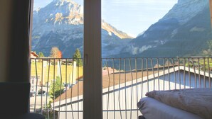 A room with a view of mountains through a window. - Eiger Lodge Chic (Grindelwald)