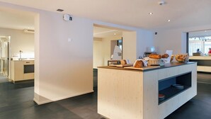 A modern kitchen area with a wooden counter, a bread basket, and a loaf of bread. - Eiger Lodge Chic (Grindelwald)