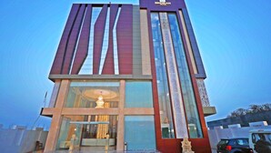 Un hotel moderno con un letrero llamativo, amplias ventanas y una entrada bien iluminada.