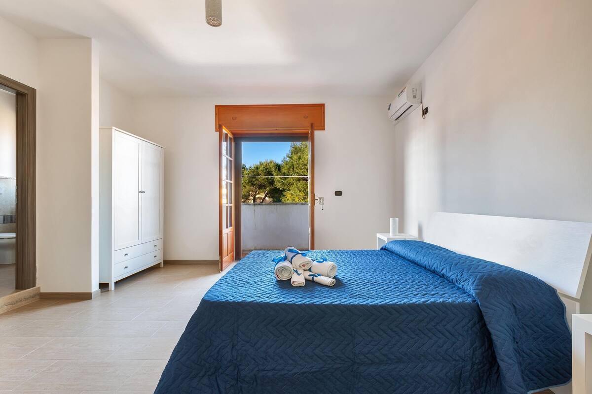 Une chambre à coucher avec un lit, une armoire et une vue sur l’extérieur.