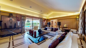 A spacious living room with a large sofa, coffee table, and a view of the outdoors.