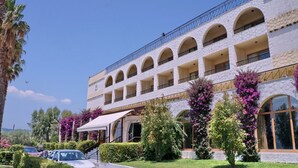 A multi-story building with a white facade, arched windows, and balconies. - Silver Bay Hotel & Bungalows (Lesvos)