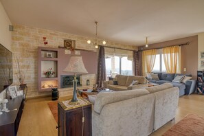 Familiehus, flere soverom, ved fjell (The House Olympia) | Oppholdsområde | En 21-tommers Flatskjerm-TV med kabel-kanaler samt TV og peis