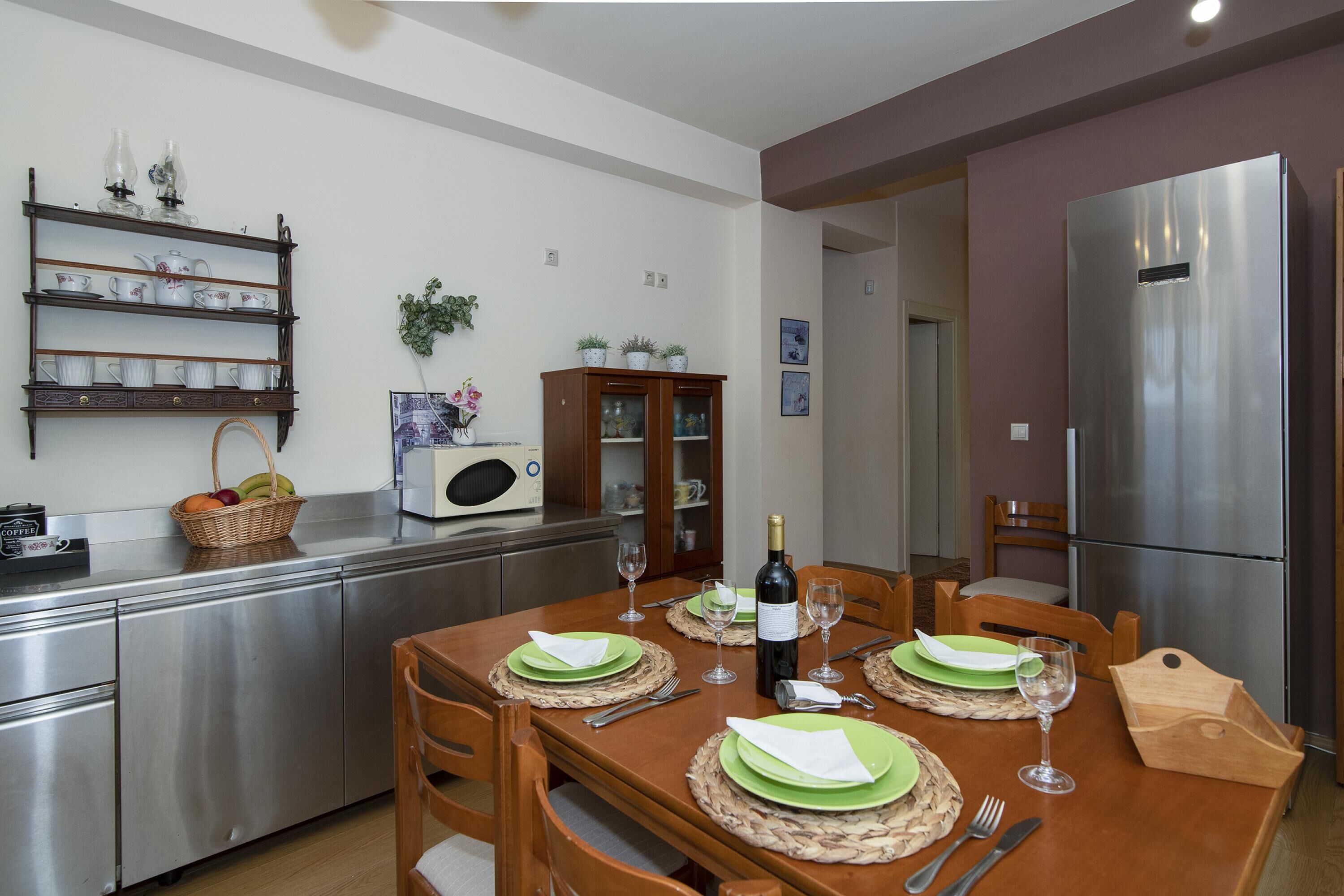 Une cuisine moderne équipée d’une table à manger pour quatre personnes, d’appareils électroménagers en acier inoxydable et d’un four à micro-ondes.