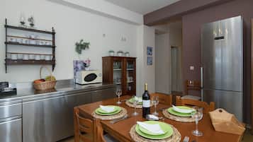 Une cuisine moderne équipée d’une table à manger pour quatre personnes, d’appareils électroménagers en acier inoxydable et d’un four à micro-ondes.