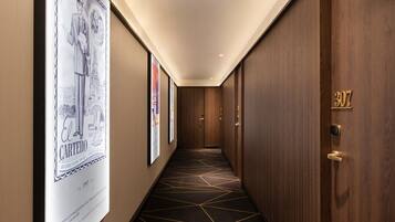 A hallway with wooden walls, a geometric patterned carpet, and a door labeled "307".
