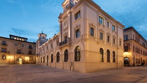Ein historisches Gebäude mit klassischer Architektur, das gewölbte Fenster und einen zentralen Turm zeigt.