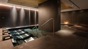 A modern spa area with a glass-enclosed hot tub, a seating area, and a geometric ceiling design. - Áurea Palacio de Correos by Eurostars Hotel Company (Logroño)
