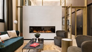 Eine moderne Hotelhalle mit Kamin, Sitzgelegenheiten und einer Rezeption.