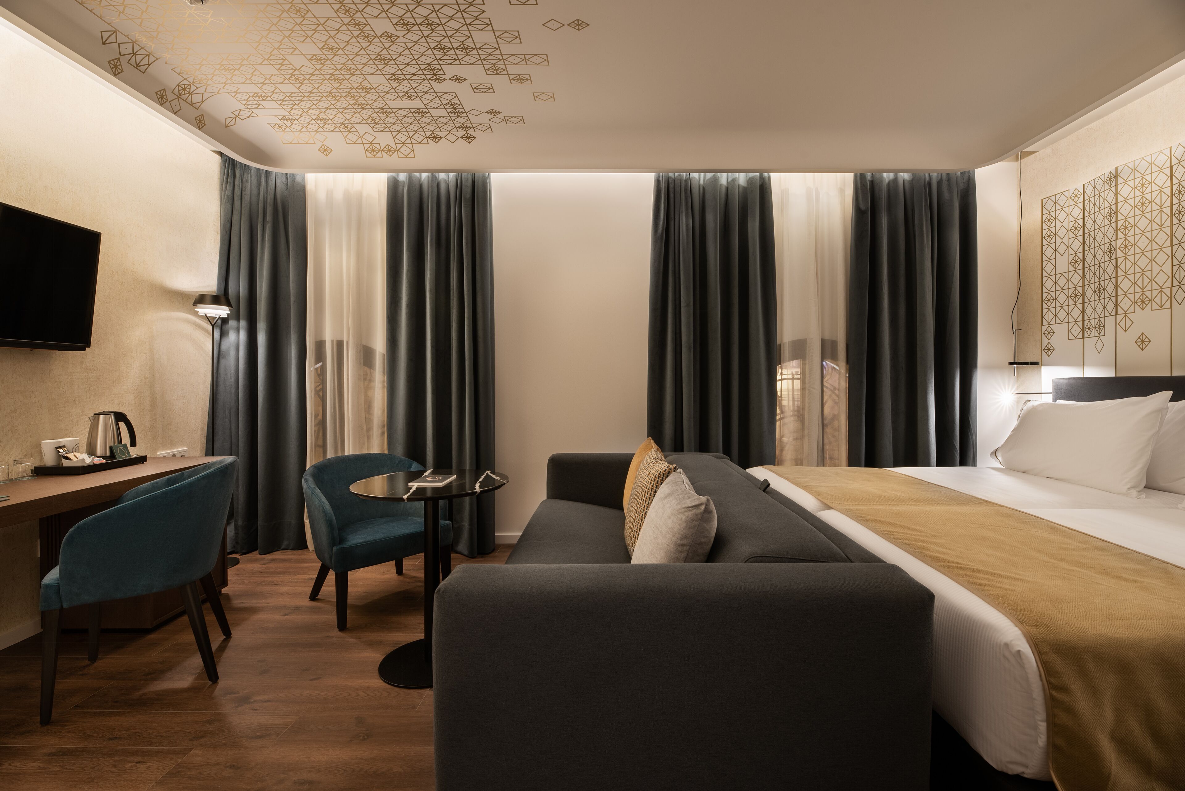 Una habitación de hotel con cama, escritorio, silla y televisión.
