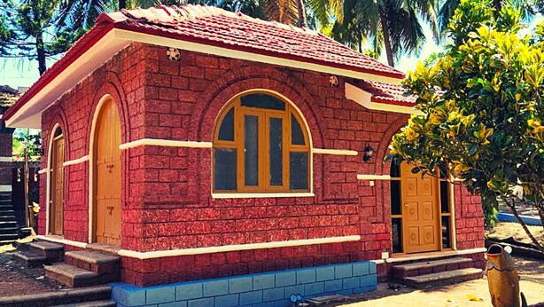 A small, red brick building with a tiled roof, a large arched window, and a door. - ShriGo Bekal Fort Resort & Spa (Hosdurg)
