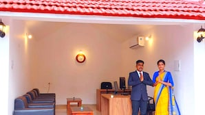 A room with a red-tiled roof, a clock on the wall, a desk with a computer, and a sofa set. - ShriGo Bekal Fort Resort & Spa (Hosdurg)