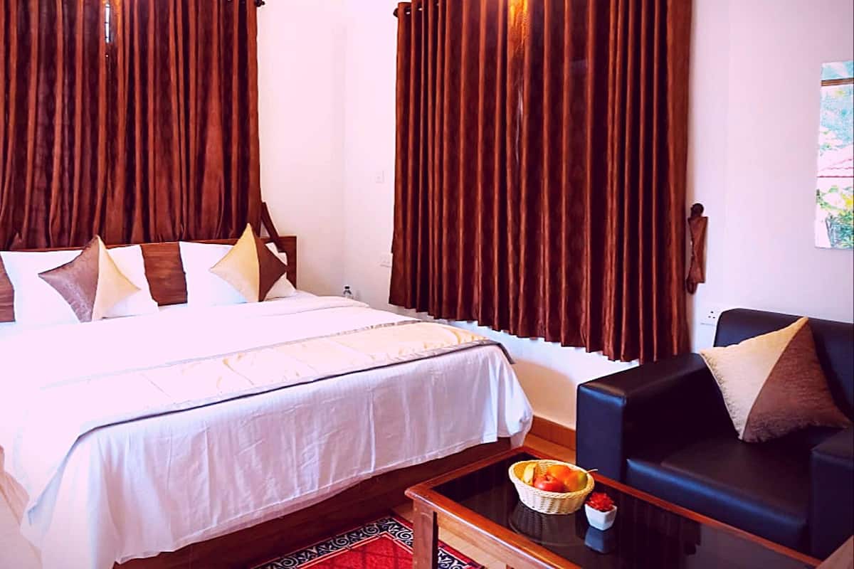 Une chambre d’hôtel avec un lit, un canapé, une table avec des fruits et des rideaux.