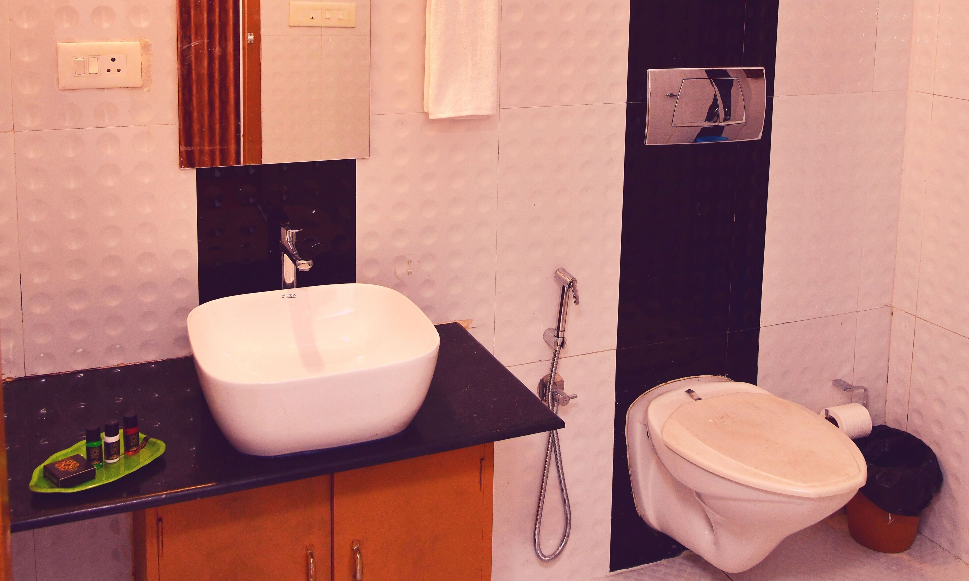 A bathroom with a white sink, black countertop, and a toilet.