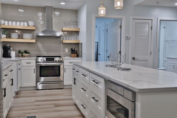 Enjoy cooking in this well-equipped kitchen with a central island, stainless steel range, and cabinets.