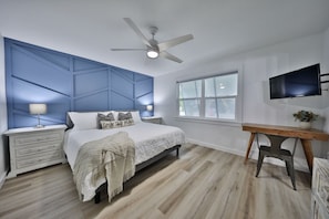 Relax in a serene bedroom with a comfortable bed, bedside table, and ceiling fan.