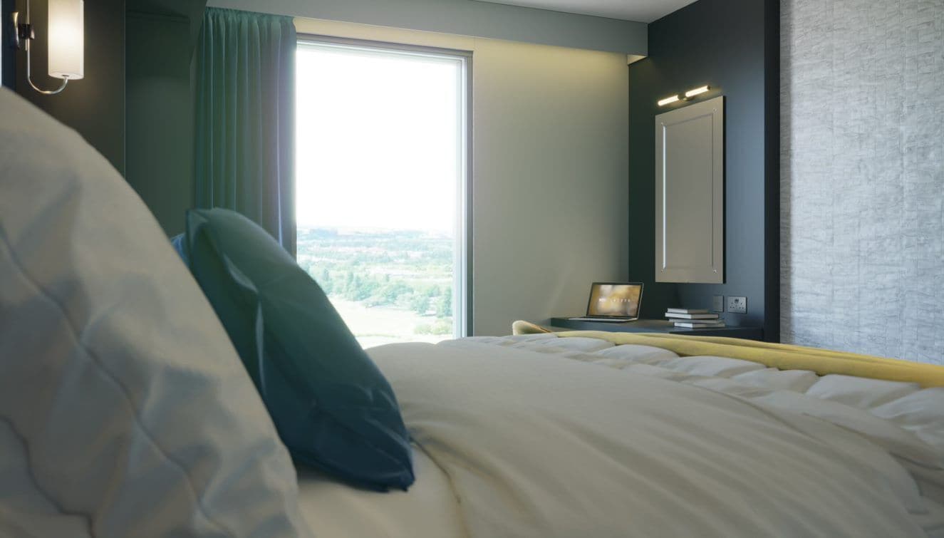 A hotel room with a large bed, a nightstand with a lamp, a window with curtains, and a view of the outdoors.