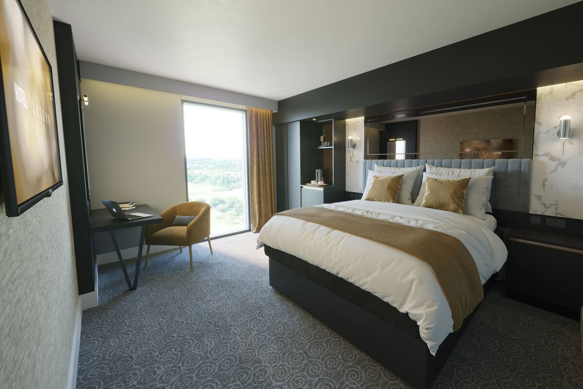 A modern hotel room with a large bed, a desk, and a chair.