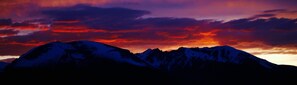 La silhouette d’une chaîne de montagnes se détache sur le ciel au coucher du soleil.