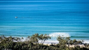 A coastal view with a beach, ocean, and a boat in the distance. - Panoramic Ocean Views At Maroochydore (Maroochydore Region)