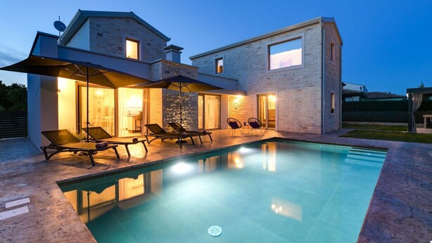 A modern house with a swimming pool, lounge chairs, and a covered patio area. - Lovely Villa Maslina with a pool (Nova Vas)