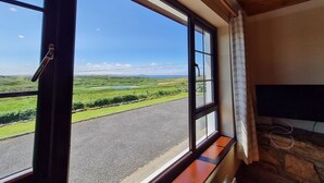 Una habitación con un ventanal que ofrece vistas a un paisaje verde y una carretera.