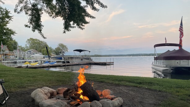 A lakeside campfire with boats docked in the background. - Lakefront home with 3 bedrooms, 2 baths, great for groups up to 10 (Shelbyville)