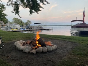 A lakeside campfire with boats docked in the background. - Lakefront home with 3 bedrooms, 2 baths, great for groups up to 10 (Shelbyville)