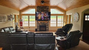 Un salón espacioso con un amplio sofá modular, una chimenea y un televisor montado en la pared.