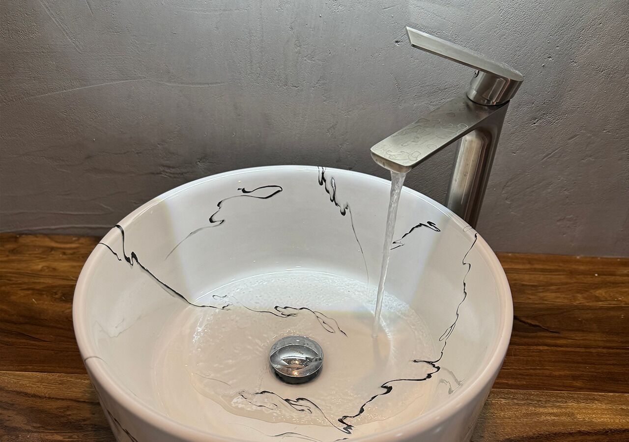 A white ceramic sink with a metallic faucet.