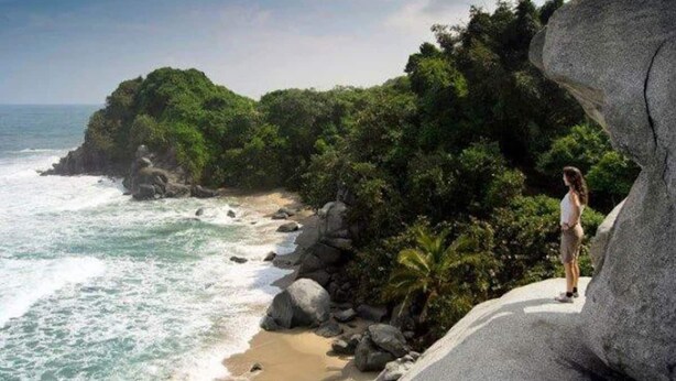 Ein Strand mit felsigem Gelände und dichter Vegetation.