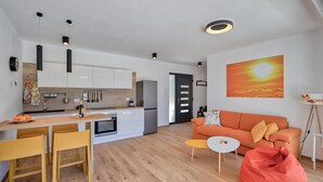 Eine moderne Küche mit weißen Schränken, einer Holzauskleidung und einem Essbereich mit gelben Stühlen.